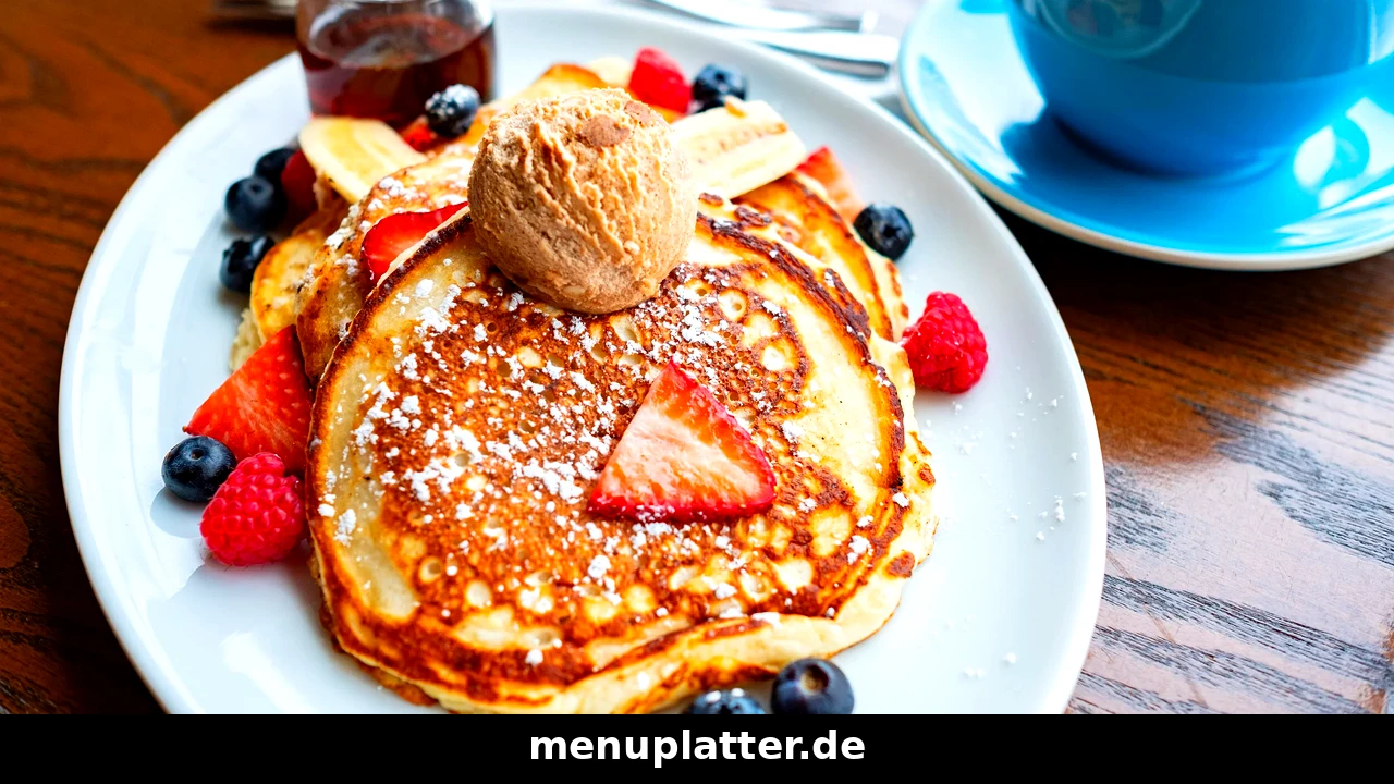 ALEX Frühstück Preise mit fluffigen Pancakes, frischen Beeren, Banane und einer Tasse Cappuccino