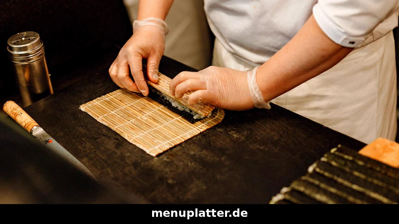 Bento Box Speisekarte Preise mit Sushi-Koch, der frische Maki-Rollen auf einer Bambusmatte formt