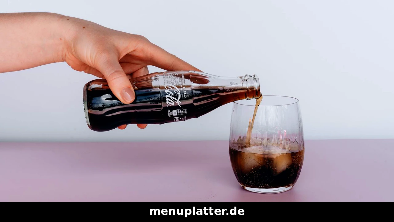 Cola Preise Restaurant mit Hand, die Cola aus einer Glasflasche in ein Glas mit Eiswürfeln einschenkt
