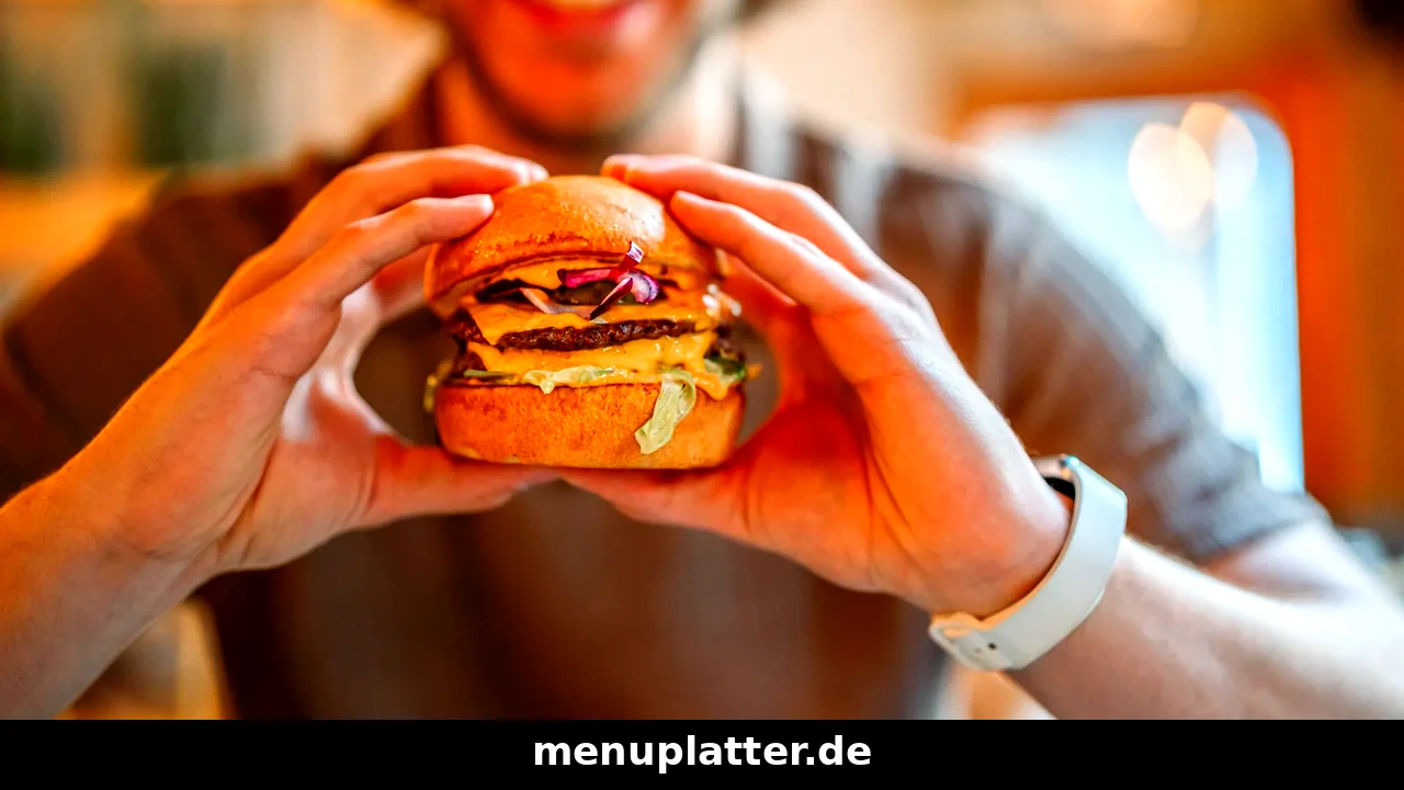 Five Guys Preise München mit einem Burger, der in einem Restaurant mit beiden Händen gehalten wird