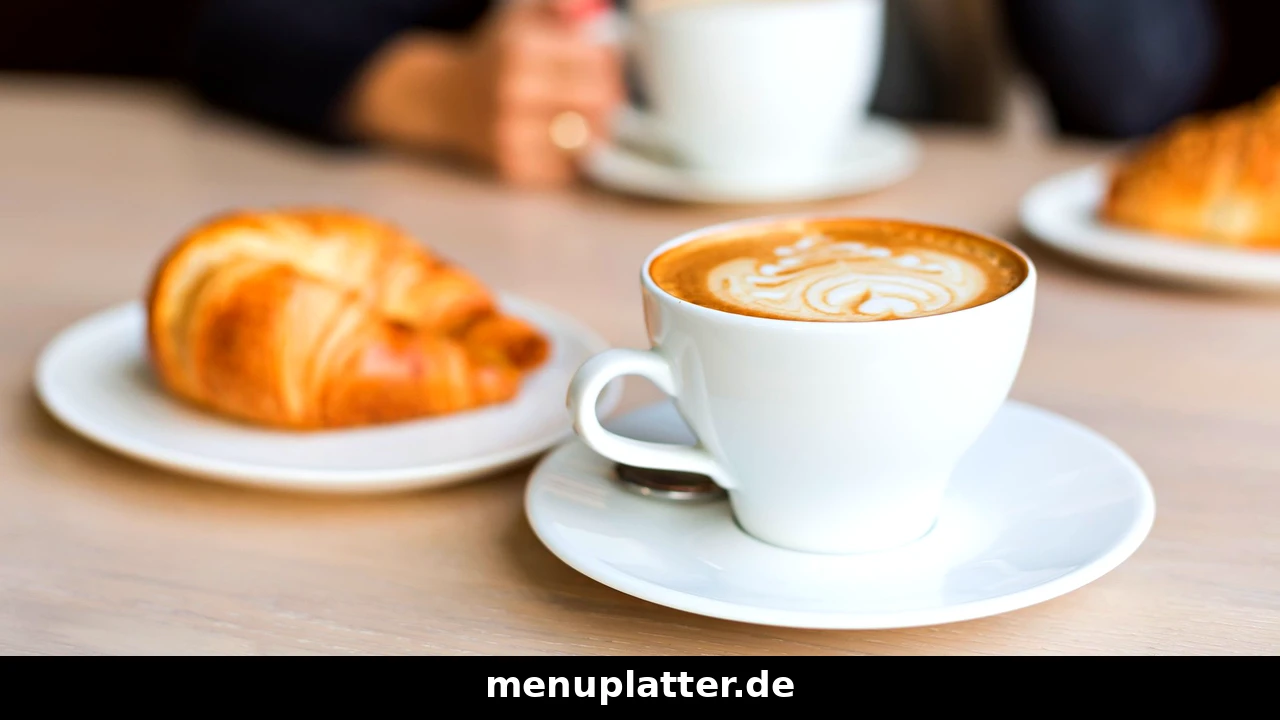 Kaffee Preise Leipzig mit einer Tasse Kaffee und einem Croissant auf einem Cafétisch