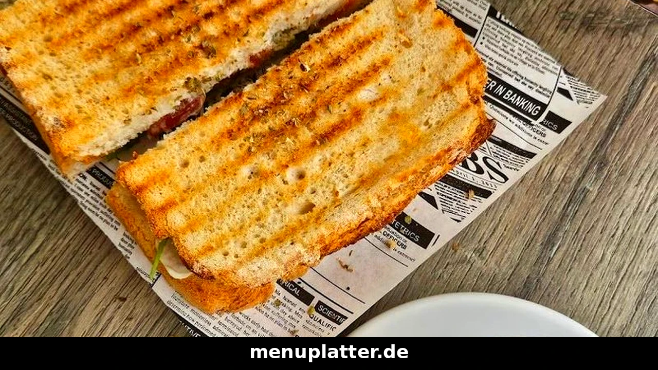 Scoom Preise mit gegrillten Panini-Sandwiches und einem Cappuccino auf einem hellen Holztisch im Café