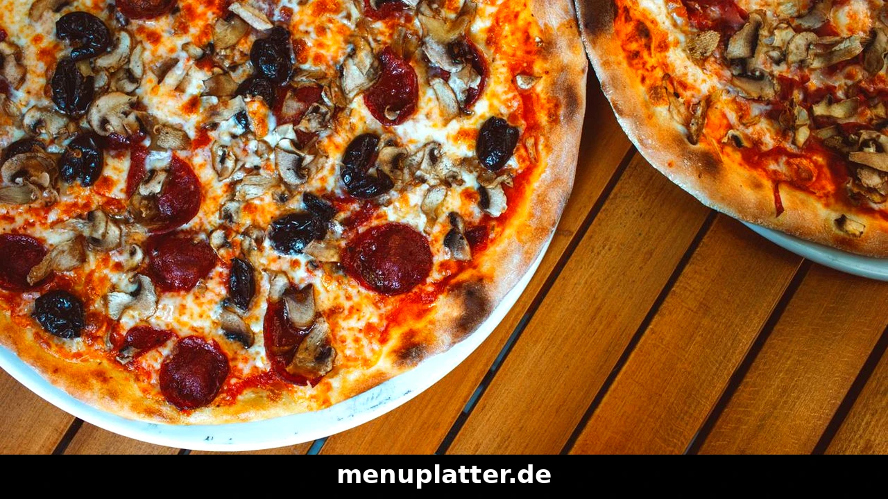 Smiley's Speisekarte Preise mit zwei Pizzen mit Salami, Champignons und Oliven auf einem Holztisch